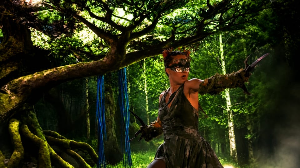 Une créature de la forêt au masque de mousse tend un gantelet griffu entre les branches